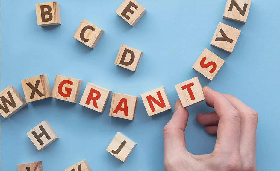 A photo of the word "GRANTS" spelled out using letter blocks.